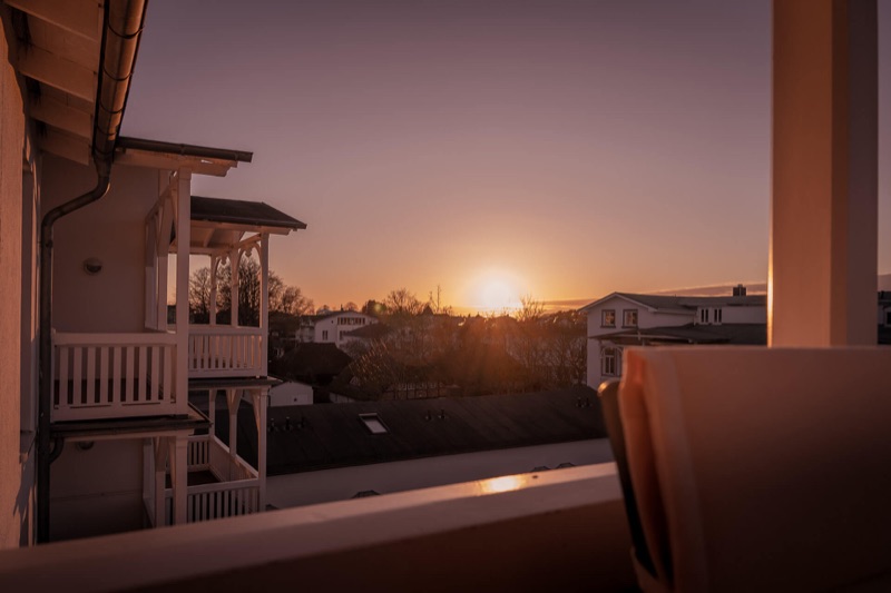 Abendrot: Sonnenuntergang über den Dächern von Göhren, vom Balkon aus gesehen